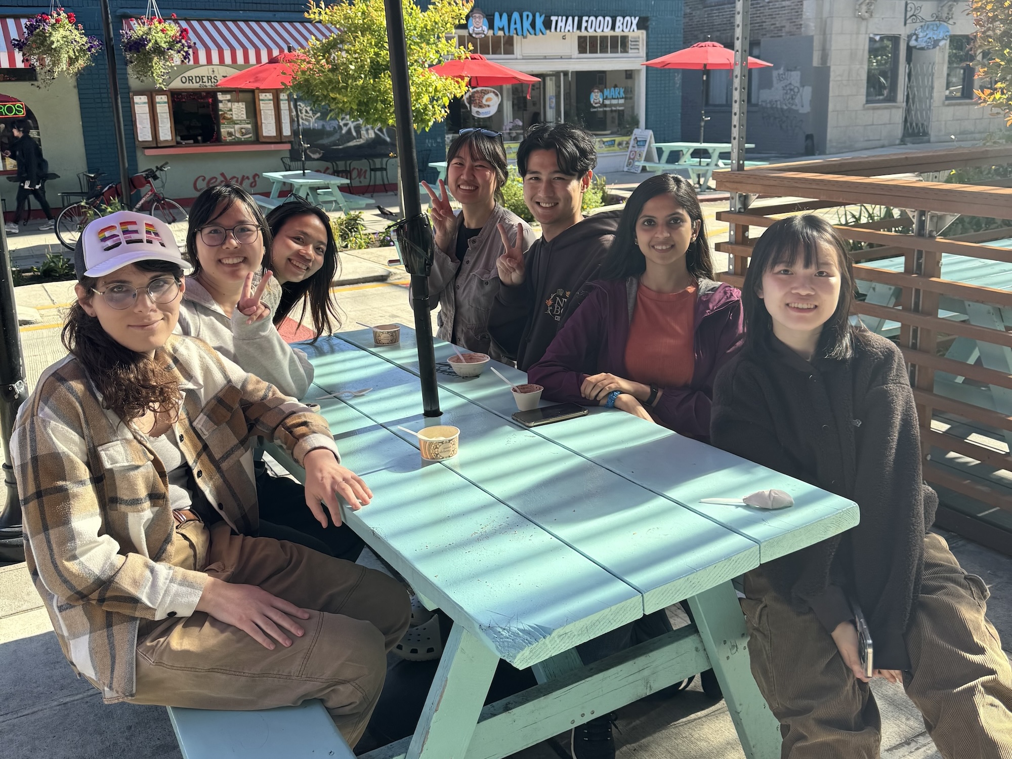 lab members sitting around a picnic table in the university district of seattle