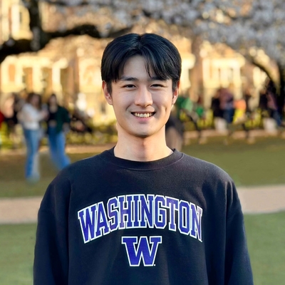 Donghoon surrounded by cherry blossoms at the quad of the UW campus