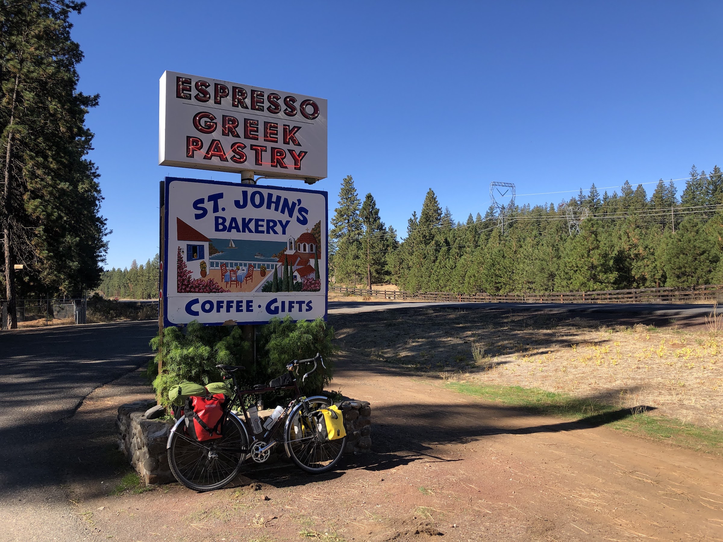 a bike leaning against a sign for St Johns bakery