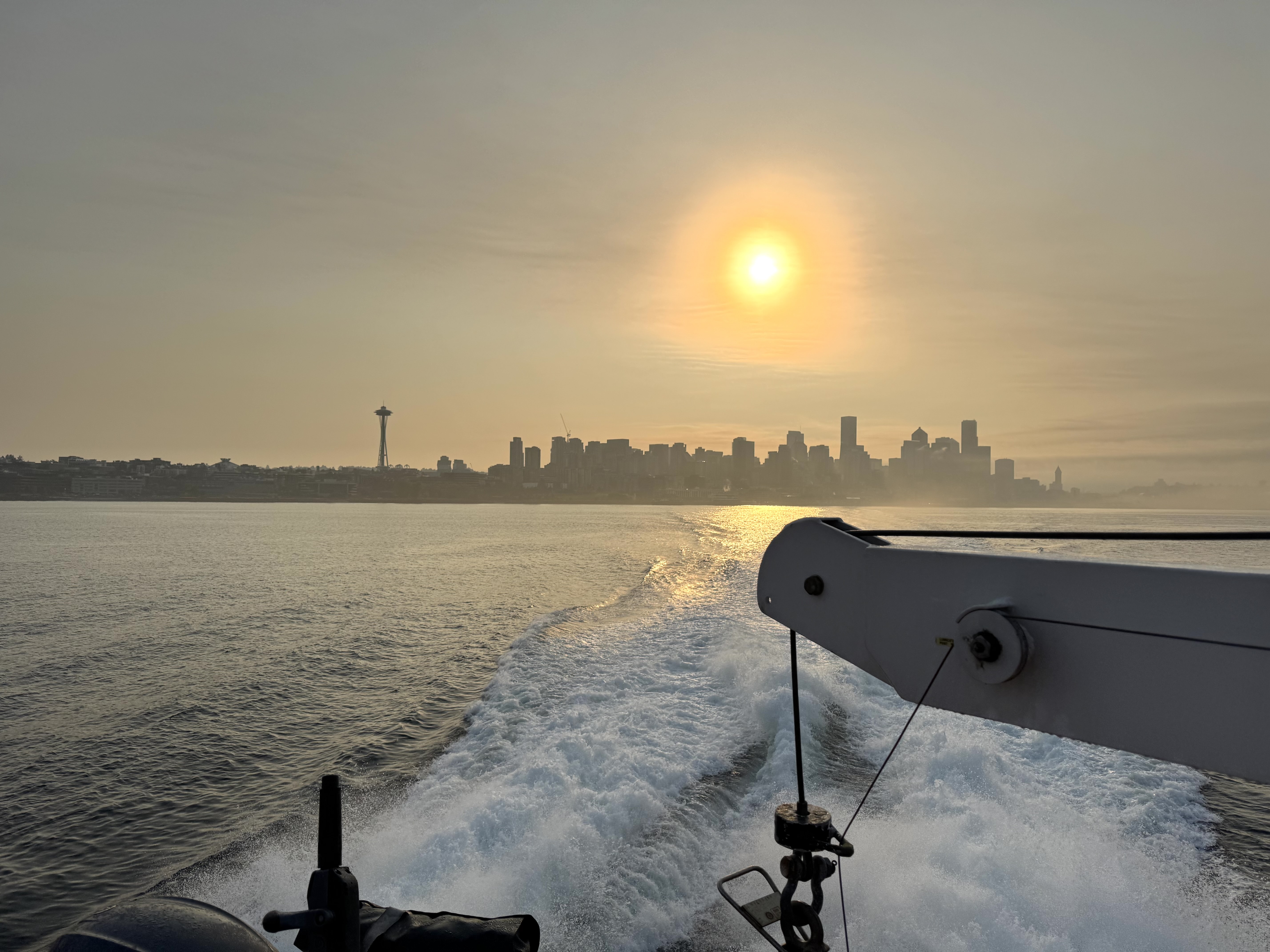 hazy morning sun yellow from smoke over seattle skyline from a ferry